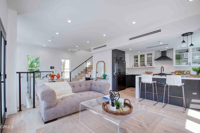 living room featuring sink and light hardwood / wood-style floors