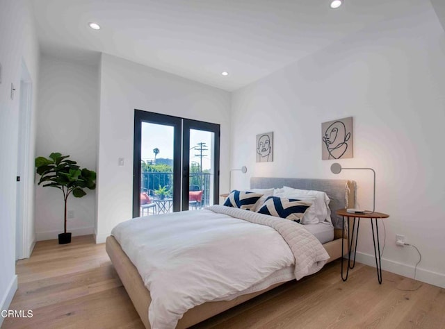 bedroom featuring access to exterior, light wood-type flooring, and french doors