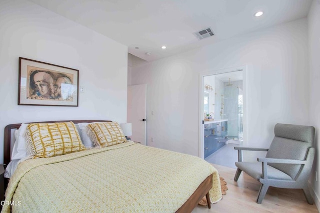 bedroom with light wood-type flooring and ensuite bathroom