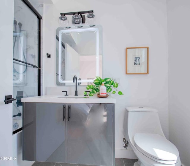 full bathroom featuring shower / bath combination with glass door, vanity, tile patterned flooring, and toilet