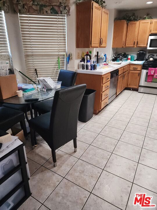 kitchen with appliances with stainless steel finishes and light tile patterned flooring