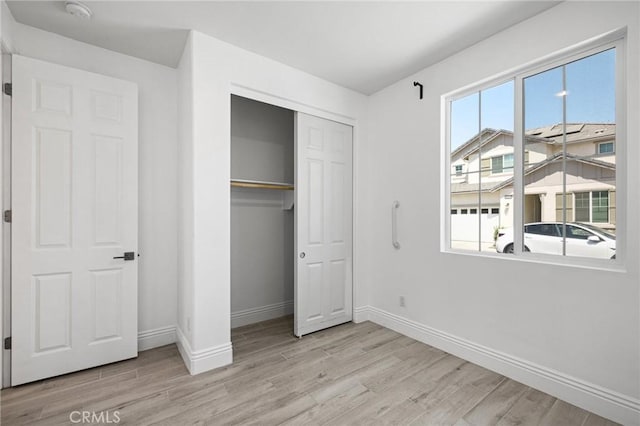 unfurnished bedroom featuring light hardwood / wood-style floors and a closet