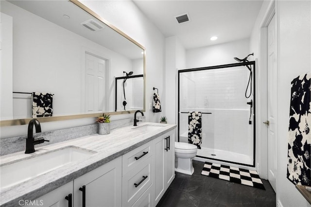 bathroom with vanity, toilet, and a shower with door