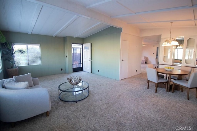 living room featuring a chandelier, lofted ceiling with beams, and carpet