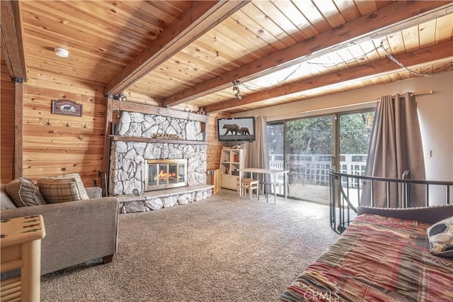 living room featuring beam ceiling, carpet flooring, wooden ceiling, a stone fireplace, and wood walls