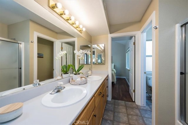 bathroom with vanity, toilet, and a shower with shower door