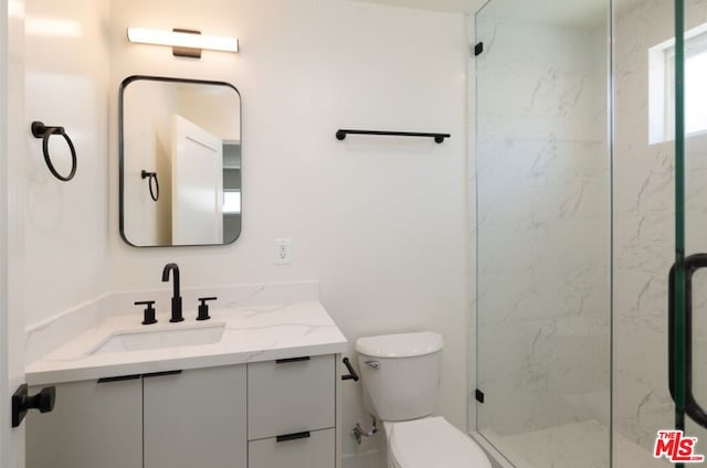 bathroom with an enclosed shower, vanity, and toilet