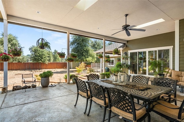 sunroom with ceiling fan and outdoor dining space