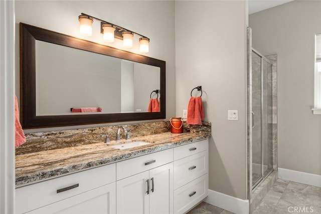 full bathroom with a stall shower, baseboards, and vanity