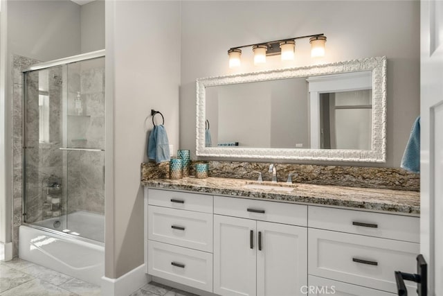 full bath featuring vanity, marble finish floor, and bath / shower combo with glass door