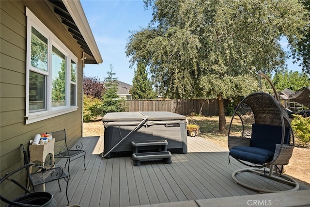 wooden terrace featuring a fenced backyard and a hot tub