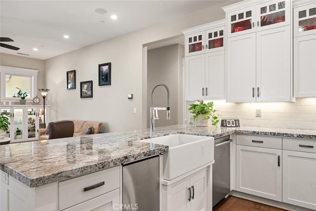 kitchen with tasteful backsplash, recessed lighting, a sink, white cabinets, and light stone countertops