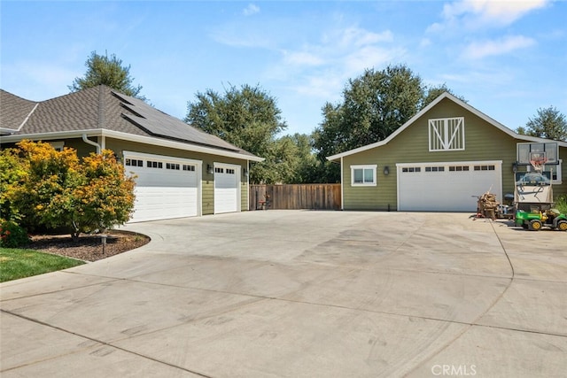 view of side of property with solar panels and a garage