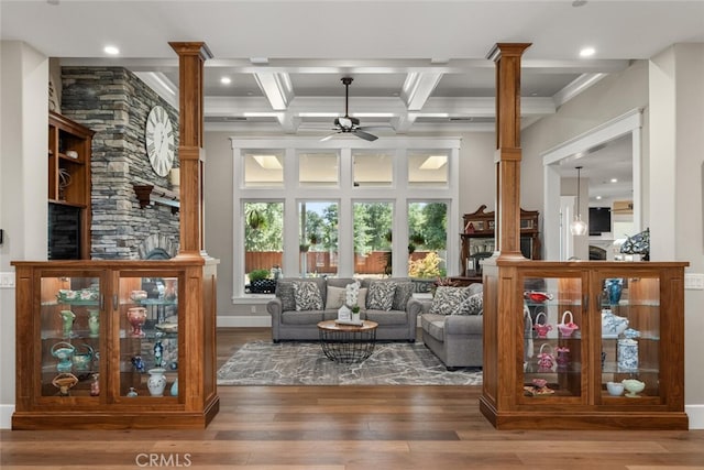 living room featuring hardwood / wood-style floors, coffered ceiling, ornate columns, and ceiling fan