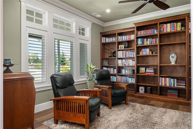 living area featuring ceiling fan, crown molding, and hardwood / wood-style flooring