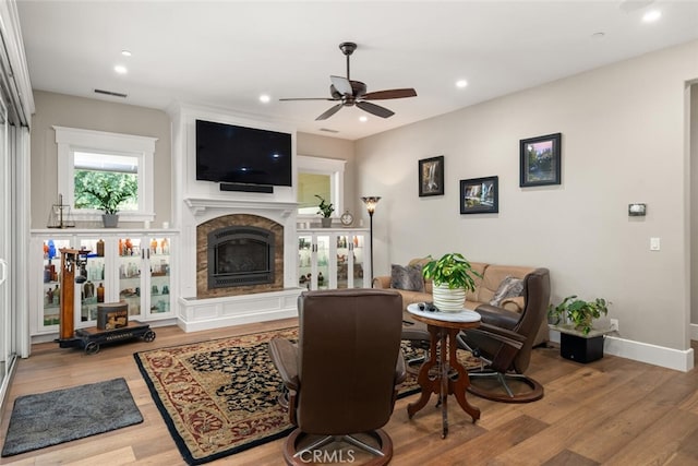 living area featuring recessed lighting, baseboards, ceiling fan, a fireplace, and wood finished floors