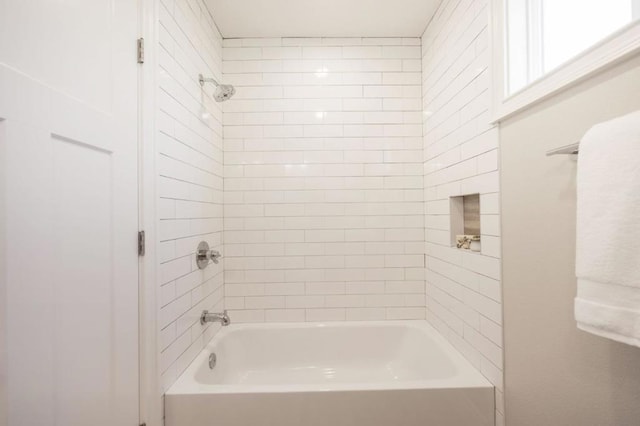 bathroom featuring tiled shower / bath