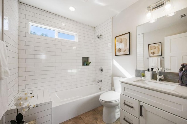 full bathroom with vanity, tile patterned flooring, tiled shower / bath combo, and toilet