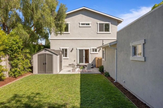 back of house featuring a patio, a yard, and a storage shed