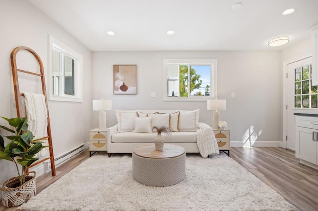 living room featuring a baseboard heating unit and hardwood / wood-style flooring