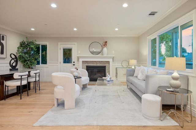 living room featuring crown molding and light hardwood / wood-style flooring