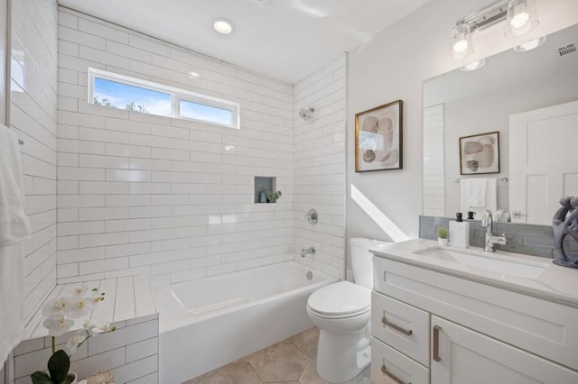 full bathroom featuring vanity, tiled shower / bath, tile patterned floors, and toilet