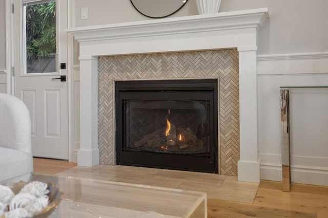 interior details featuring a tiled fireplace and hardwood / wood-style floors