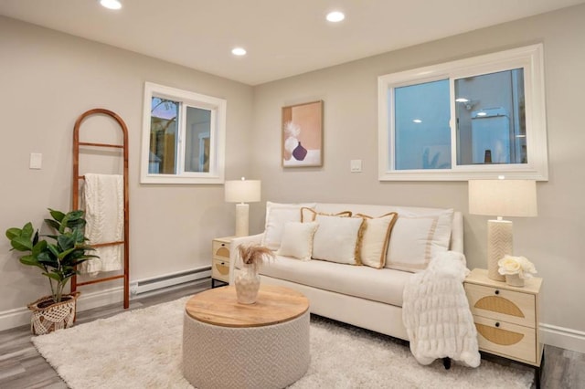 living room with a baseboard heating unit and hardwood / wood-style floors