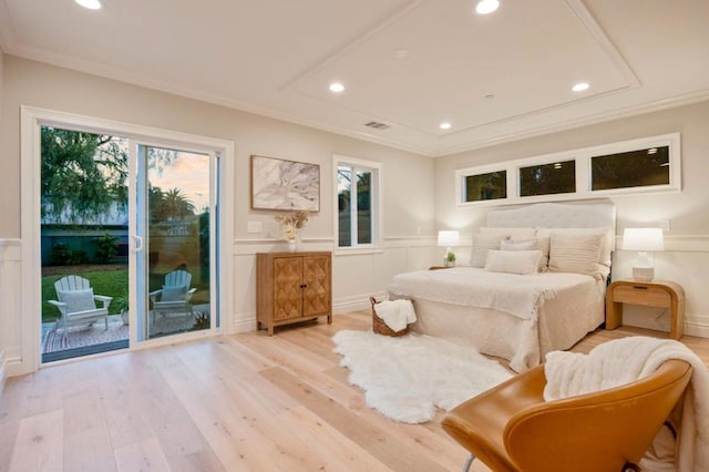 bedroom featuring multiple windows, access to exterior, light hardwood / wood-style flooring, and ornamental molding