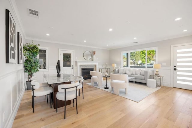 living room with crown molding and light hardwood / wood-style flooring