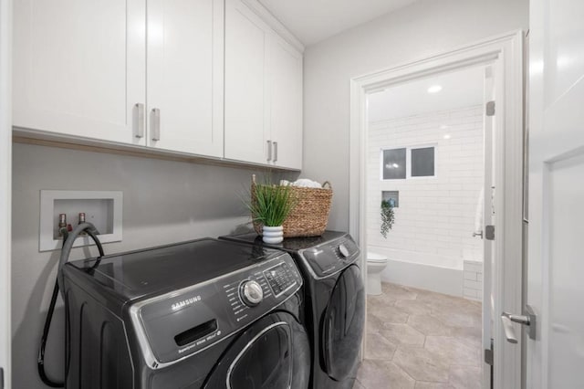 laundry room with light tile patterned floors, washing machine and dryer, and cabinets