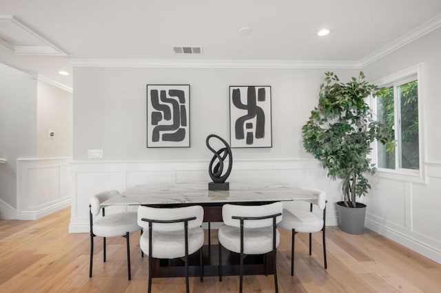 dining area featuring breakfast area, ornamental molding, and light hardwood / wood-style floors