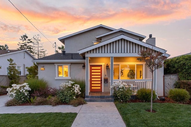 bungalow-style house with a yard and covered porch