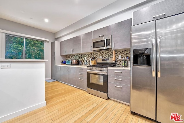 kitchen with backsplash, light hardwood / wood-style floors, and stainless steel appliances