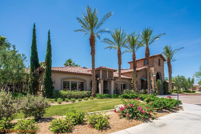 mediterranean / spanish house featuring a front yard