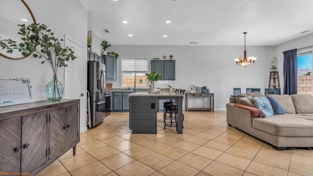 living room with light tile patterned floors, a notable chandelier, and a healthy amount of sunlight