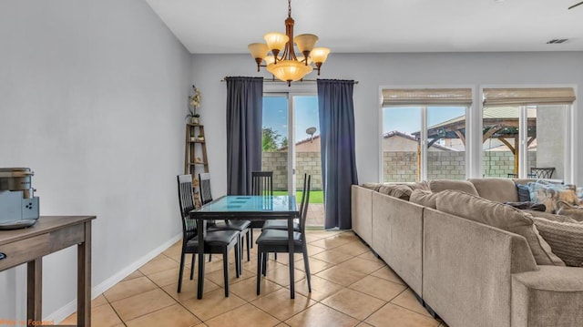 dining space with a wealth of natural light, light tile patterned floors, and a chandelier