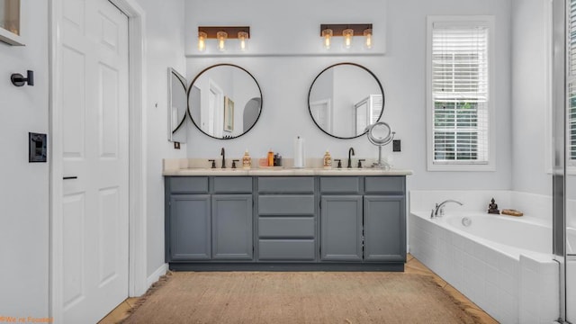 bathroom with tiled bath and vanity