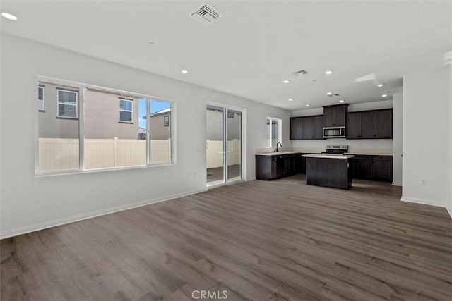 kitchen featuring sink, hardwood / wood-style floors, appliances with stainless steel finishes, and a center island