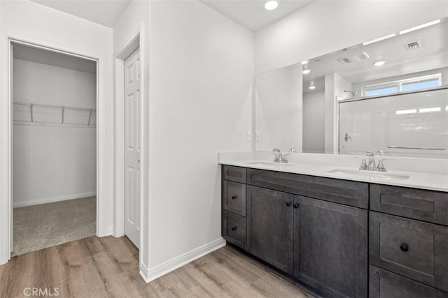 bathroom featuring a shower, wood-type flooring, and vanity