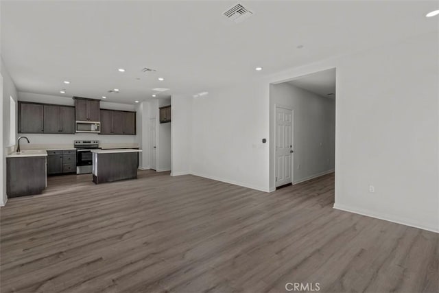 unfurnished living room featuring light wood-type flooring and sink