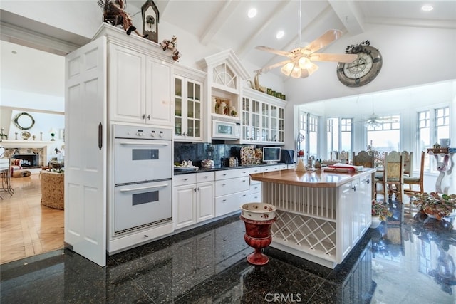 kitchen featuring backsplash, white cabinets, white appliances, and ceiling fan