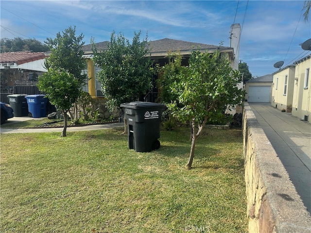 obstructed view of property with a garage, a front yard, and an outbuilding