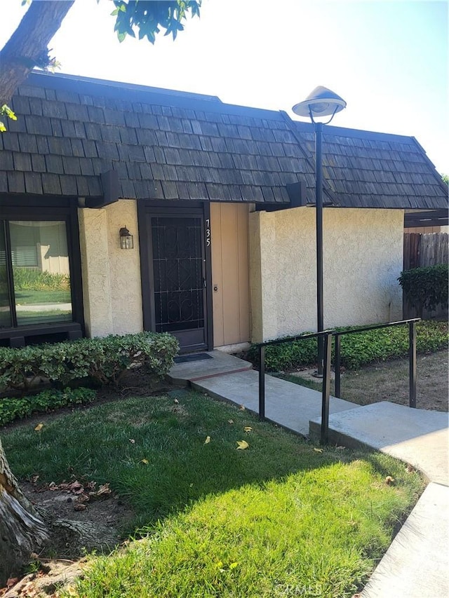 doorway to property featuring a yard