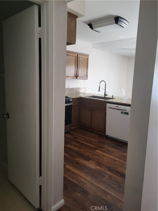 kitchen featuring stove, sink, white dishwasher, a textured ceiling, and dark hardwood / wood-style flooring