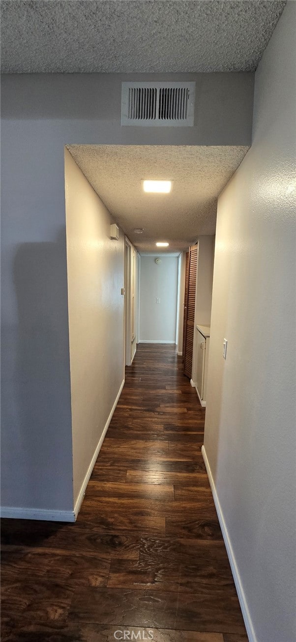 hall featuring dark hardwood / wood-style floors and a textured ceiling