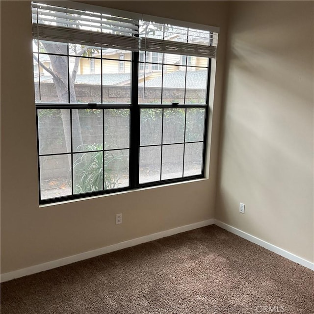 carpeted spare room featuring plenty of natural light