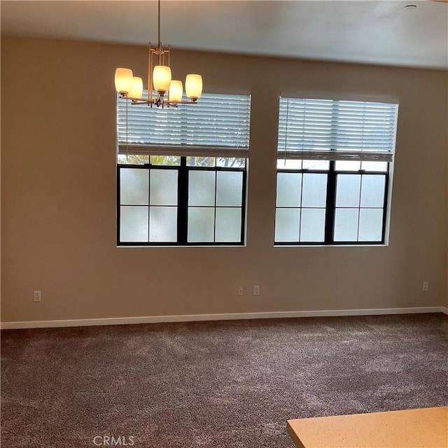 carpeted spare room with an inviting chandelier and a healthy amount of sunlight