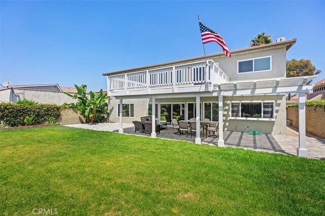 rear view of property featuring a patio area, a yard, and a wooden deck