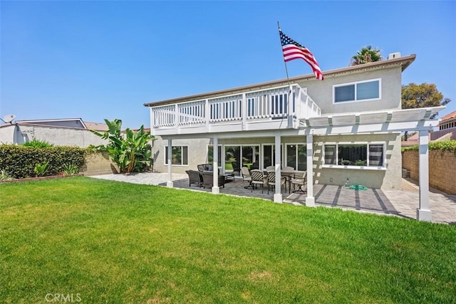 rear view of house with a deck, a yard, and a patio